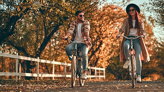 Ein Paar auf dem Fahrrad im Herbst