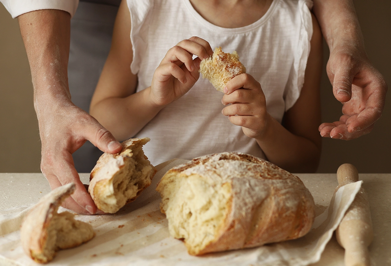 Hände bedienen sich an frisch gebackenem Brot Frau entspannt beim Yoga zu Hause