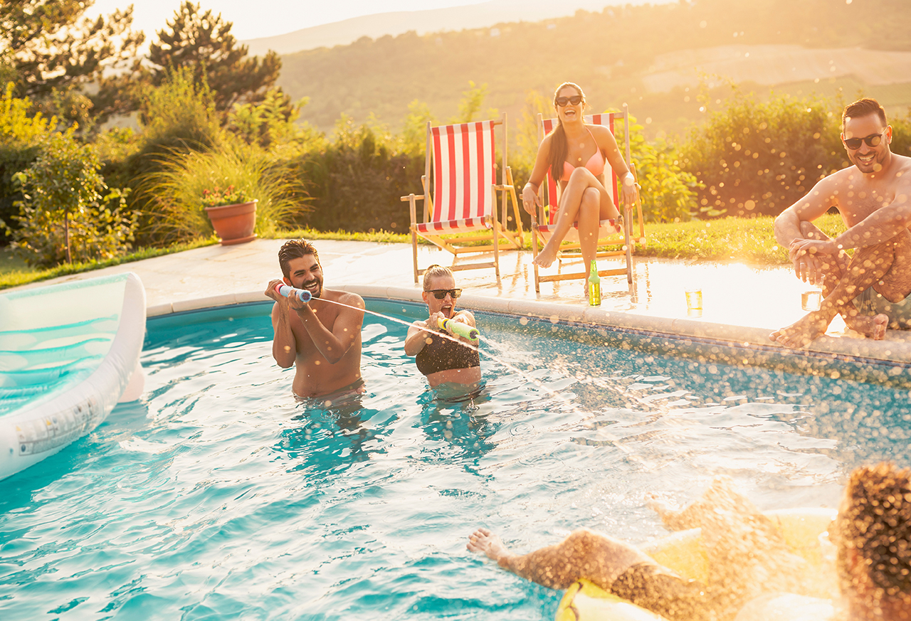 Freunde machen eine Wasserschlacht im Pool neu Frau entspannt beim Yoga zu Hause