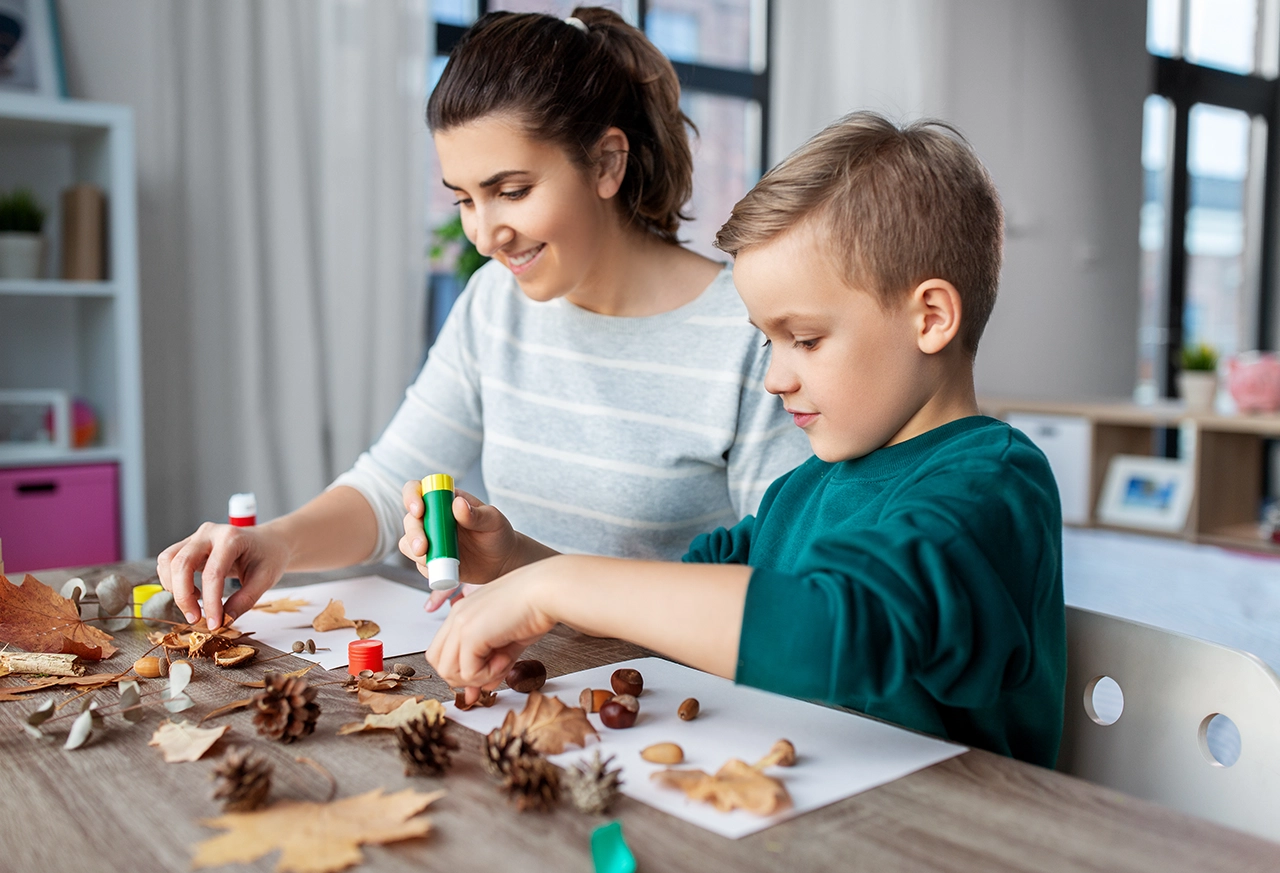 Mutter und Sohn basteln mit Herbstlaub Frau entspannt beim Yoga zu Hause